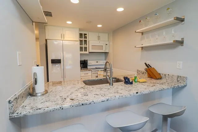 a kitchen with stainless steel appliances granite countertop a sink refrigerator and cabinets
