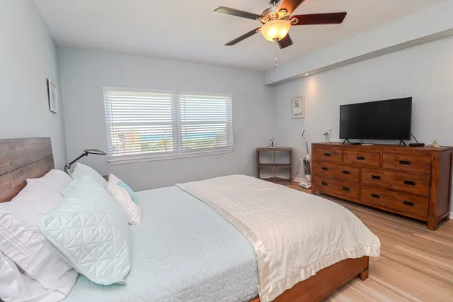 a bedroom with a bed and a flat tv screen on dresser