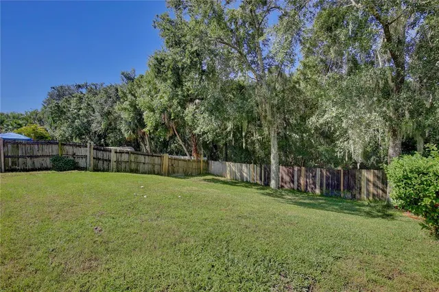 a view of a backyard with a garden and entertaining space