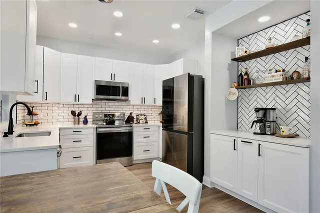 a kitchen with stainless steel appliances a refrigerator sink and cabinets