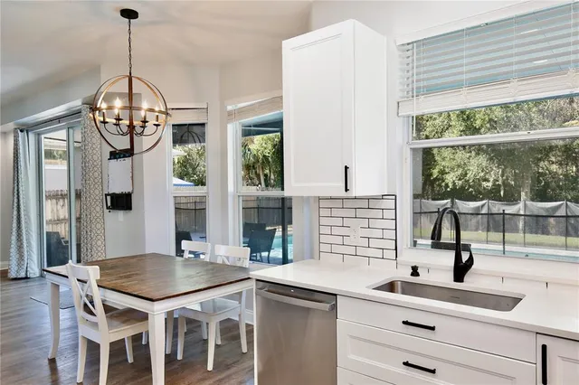a kitchen with a sink a counter top space and living room view