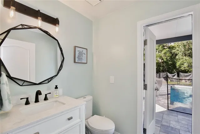a bathroom with a sink mirror vanity and toilet