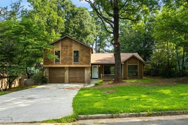 a front view of a house with a yard and trees