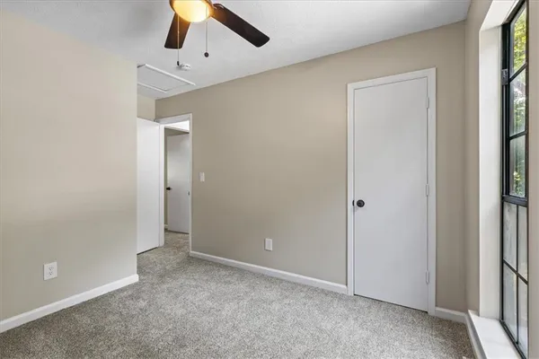 an empty room with closet and a chandelier fan