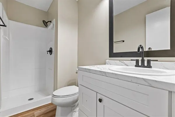 a bathroom with a sink a toilet and shower