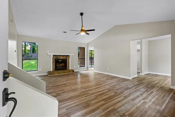 a view of empty room with fireplace and wooden floor