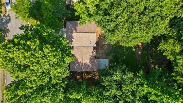 an aerial view of a house with a yard and tree s