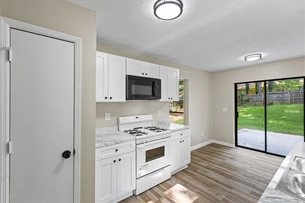 a kitchen with a stove a sink and a microwave