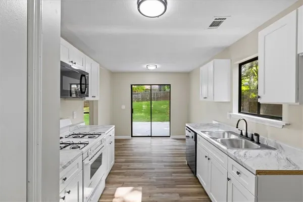 a kitchen with a sink stove and wooden cabinets