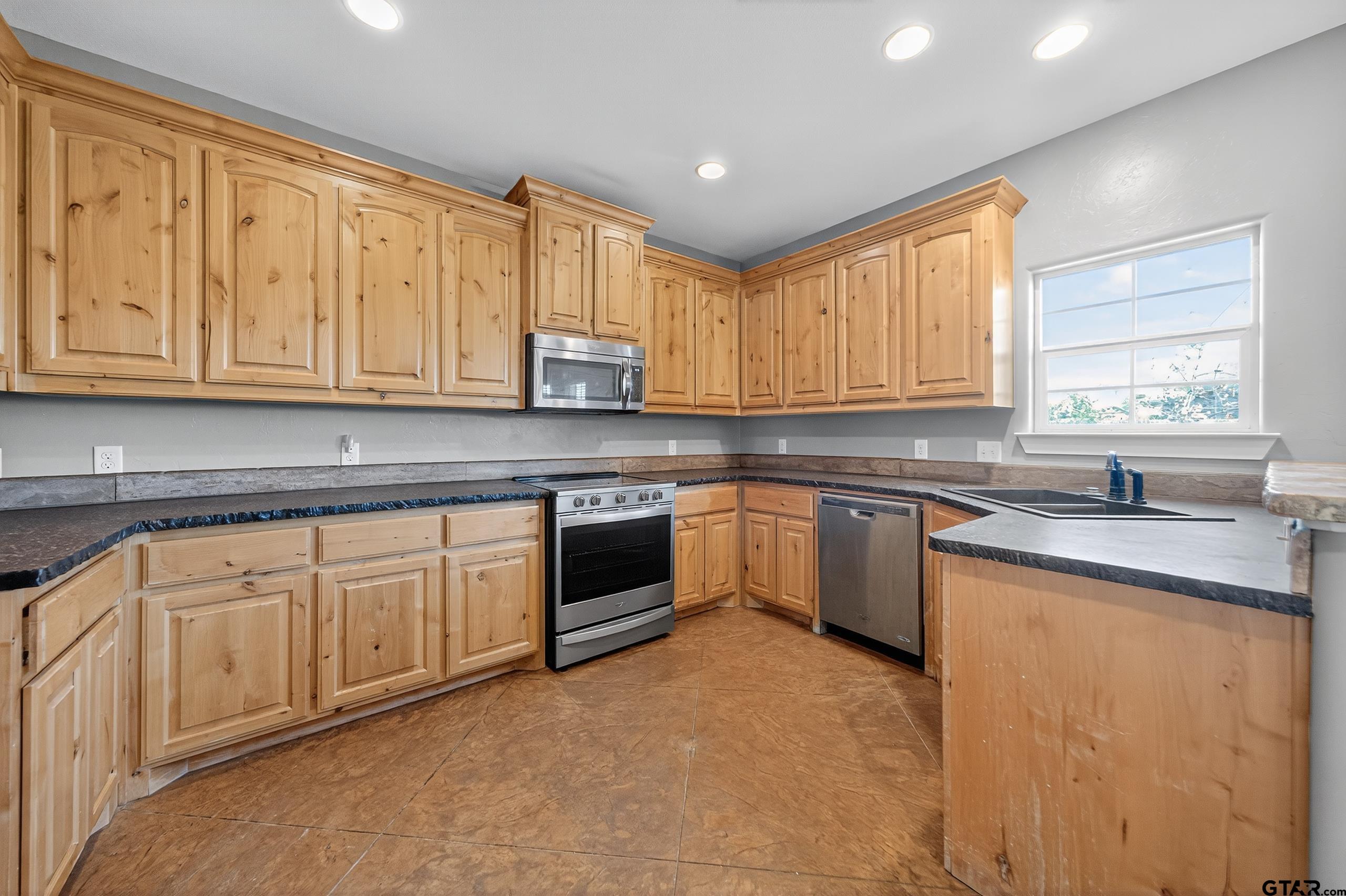 709 Linus Lane Lindale, TX 75771 - Photo 17 of 40 a kitchen with granite countertop cabinets stainless steel appliances a sink and window