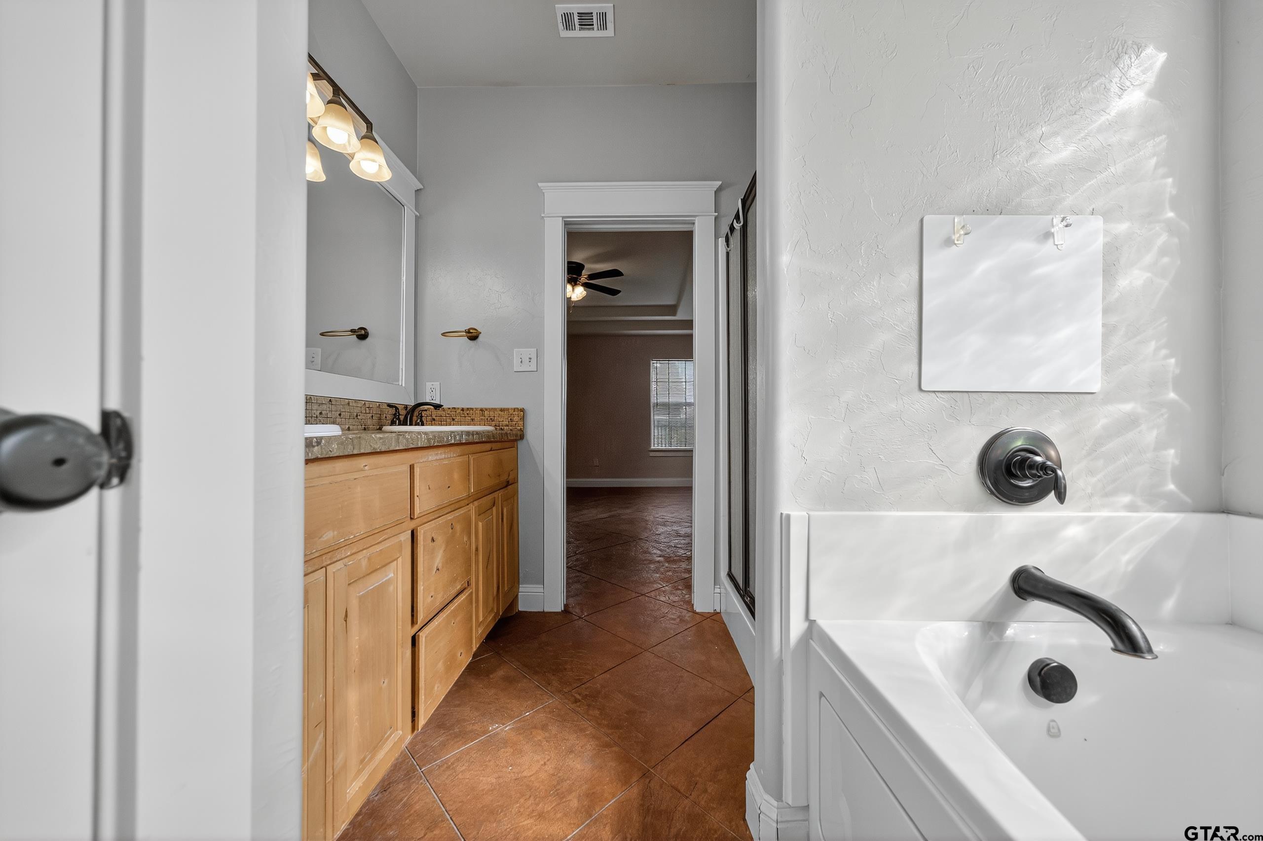 709 Linus Lane Lindale, TX 75771 - Photo 26 of 40 a bathroom with a tub sink and mirror