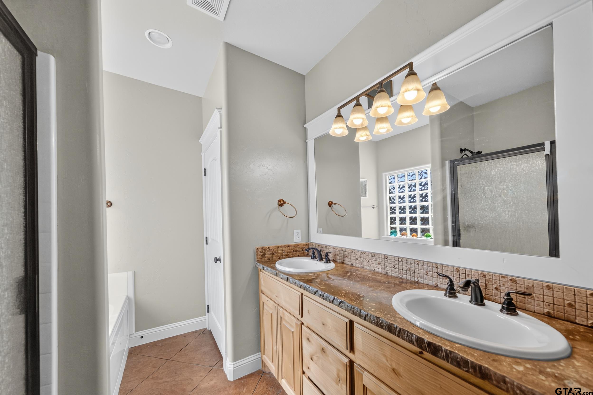 709 Linus Lane Lindale, TX 75771 - Photo 27 of 40 a bathroom with a granite countertop sink and a mirror