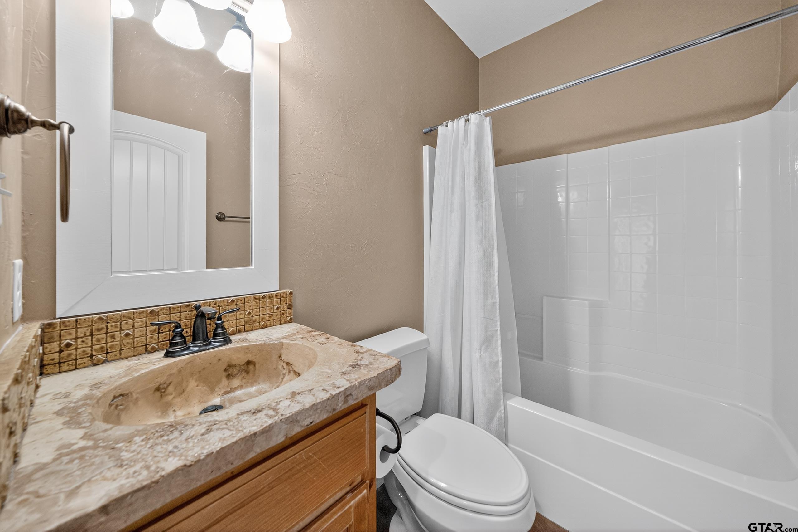 709 Linus Lane Lindale, TX 75771 - Photo 34 of 40 a bathroom with a granite countertop sink toilet and shower