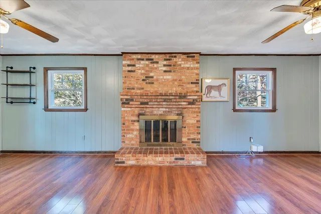 a view of a big room with wooden floor and windows
