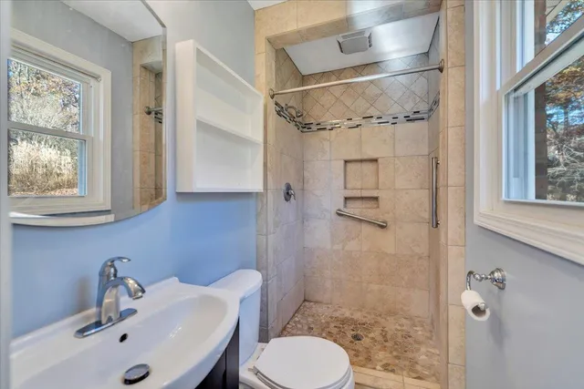 a bathroom with a sink a toilet and shower