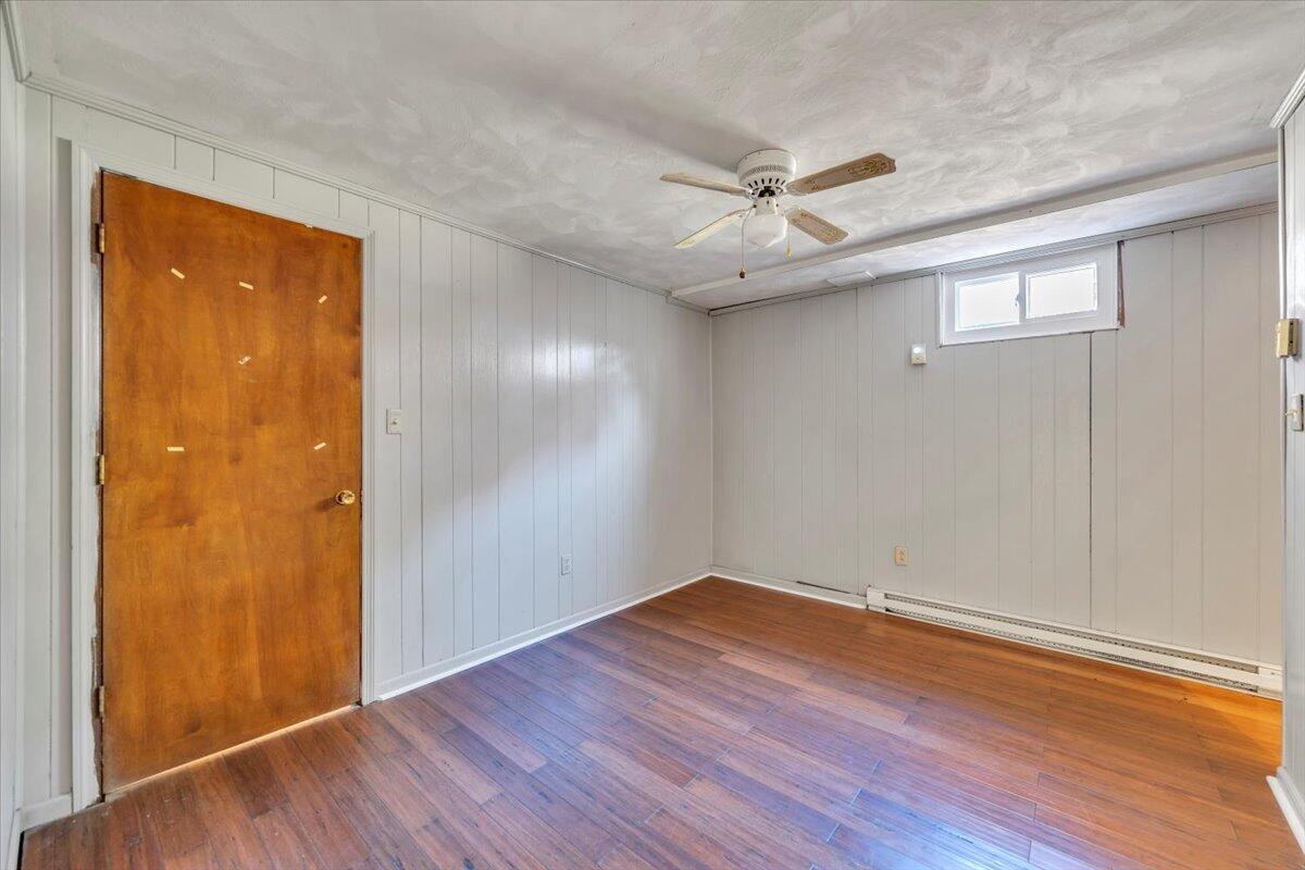 2216 East Ruritan Road Roanoke, VA 24012 - Photo 37 of 57 an empty room with wooden floor a ceiling fan and windows