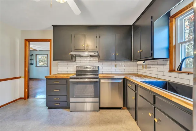 a kitchen with stainless steel appliances granite countertop a refrigerator and a sink