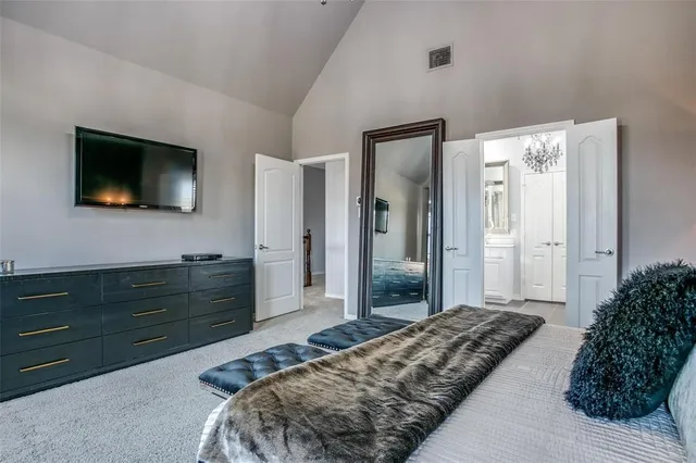 a bedroom with a large bed and a chandelier