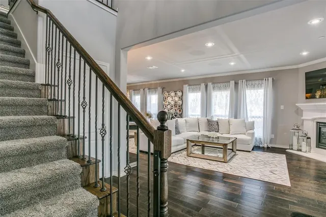 a living room with furniture and wooden floor next to a window