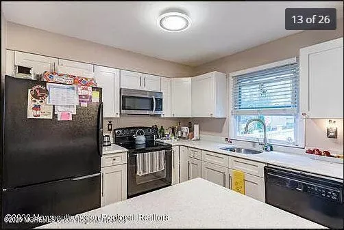 a kitchen with stainless steel appliances granite countertop a refrigerator sink stove microwave and cabinets
