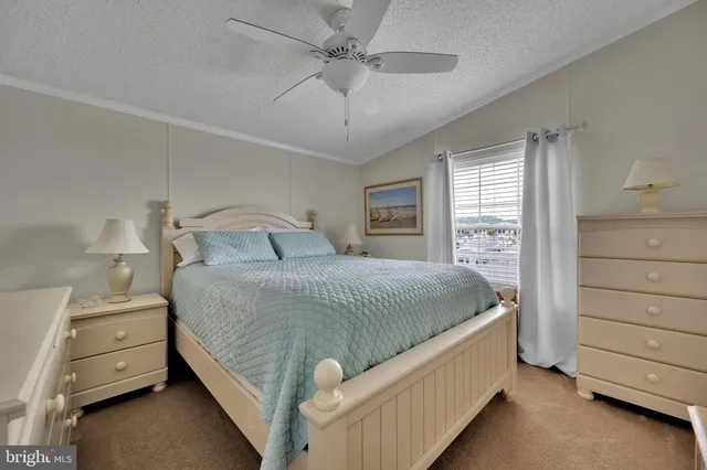 a white house that has a small yard and large trees