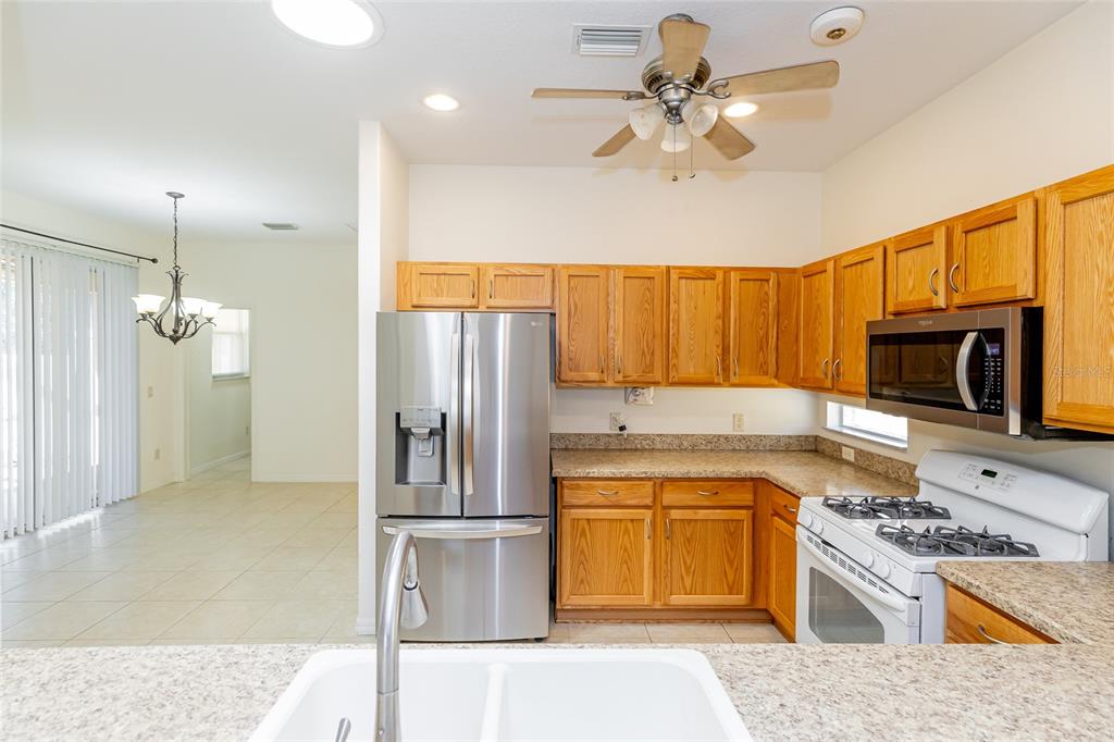 16299 Southwest 14th Avenue Road Ocala, FL 34473 - Photo 23 of 50 a kitchen with a sink a stove and a refrigerator