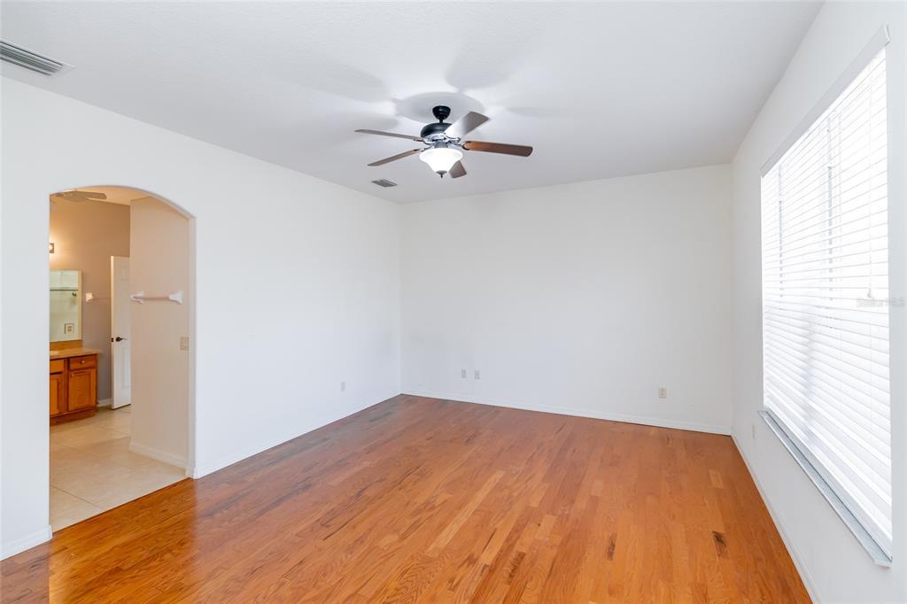 16299 Southwest 14th Avenue Road Ocala, FL 34473 - Photo 28 of 50 a view of a big room with wooden floor a chandelier fan and windows