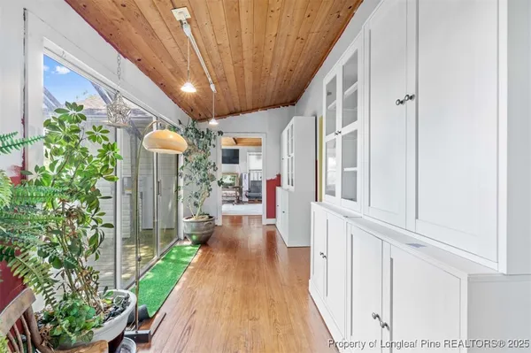 a view of a house next to a big yard and large trees