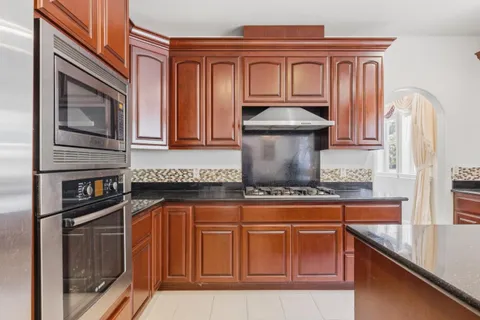 a kitchen with stainless steel appliances granite countertop a sink stove and cabinets