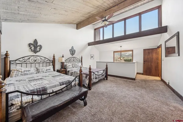 a bedroom with a bed and a large mirror on the dresser