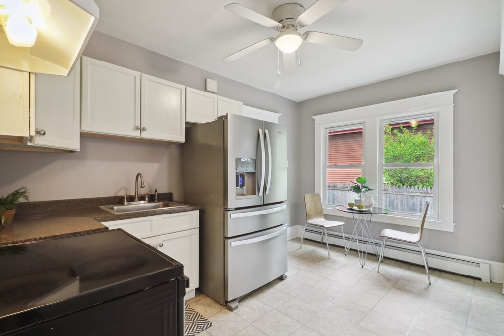 33 Crest Street Springfield, MA 01109 - Photo 10 of 28 a kitchen with a stove a refrigerator and furniture