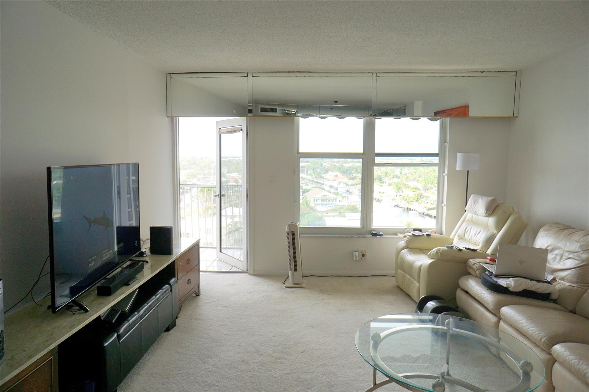 303 North Riverside Drive, Unit PH4 Pompano Beach, FL 33062 - Photo 6 of 52 a living room with furniture and a flat screen tv