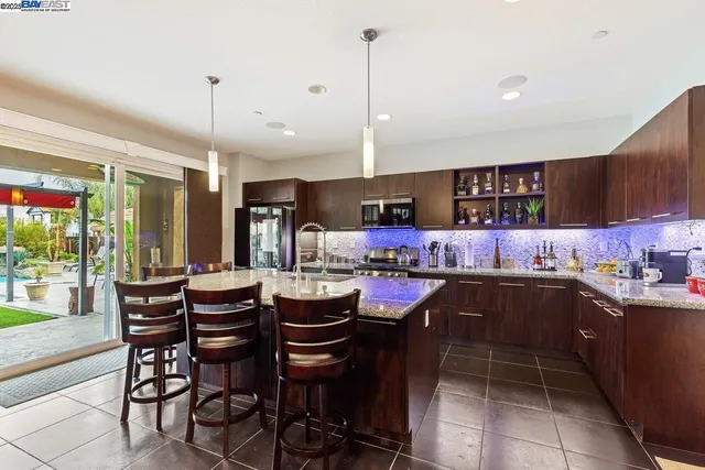 a kitchen with a dining table chairs and large window