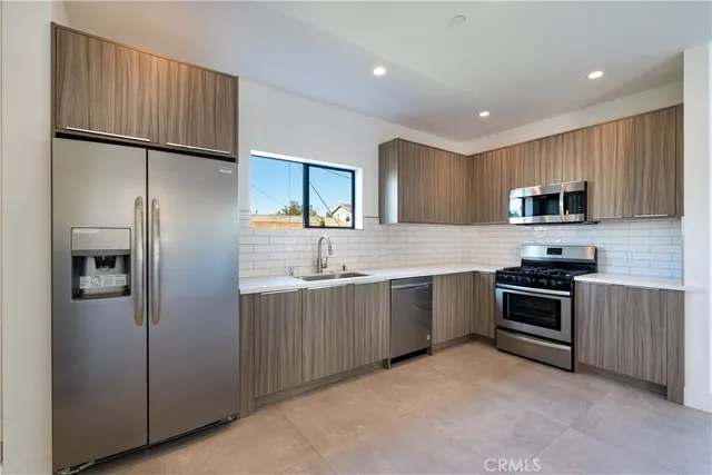 a kitchen with granite countertop stainless steel appliances and refrigerator