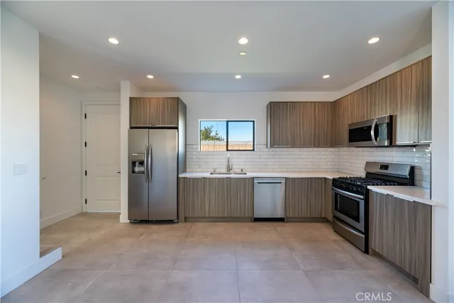 a kitchen with granite countertop a stove and a microwave