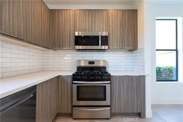 a view of a kitchen with a sink and a refrigerator