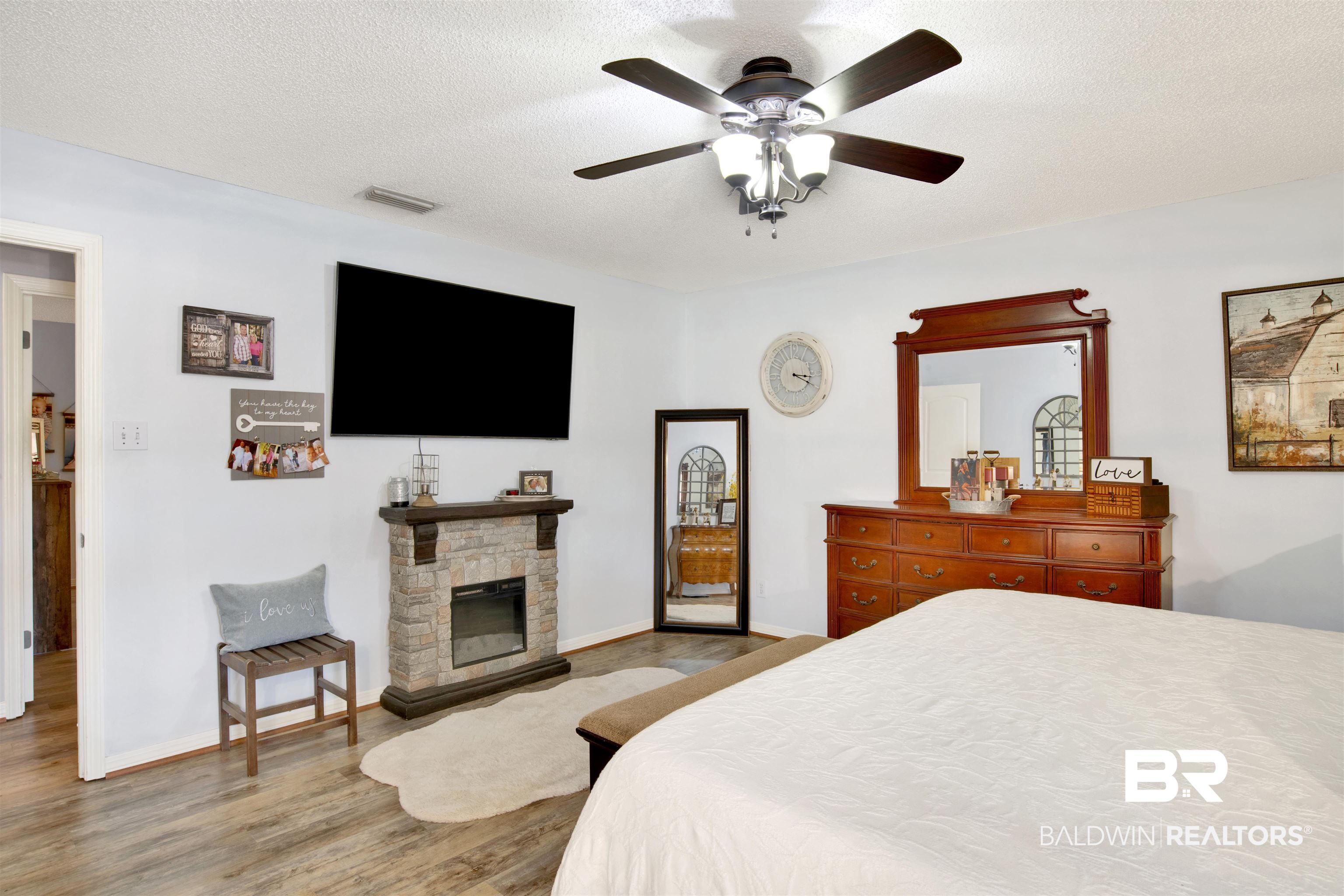 13385 Tom Gaston Road Mobile, AL 36695 - Photo 19 of 42 Bedroom featuring a textured ceiling, a fireplace, ceiling fan, and hardwood / wood-style flooring