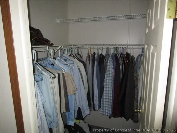 a view of walk in closet with clothes and shoes