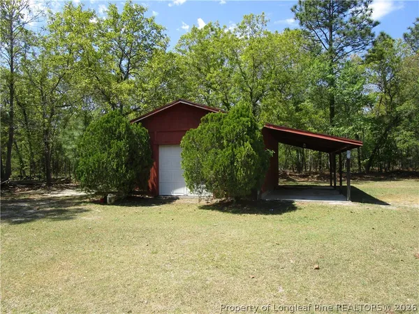 a view of backyard with a barn and large trees