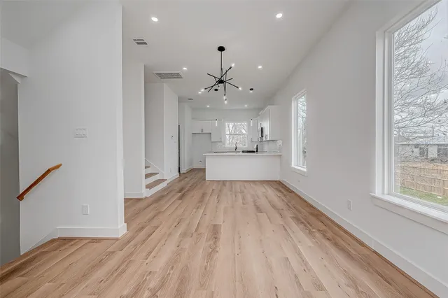 a view of a kitchen with a sink and dishwasher with wooden floor