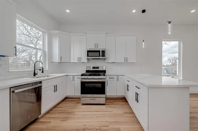 a kitchen with granite countertop a stove top oven sink and cabinets