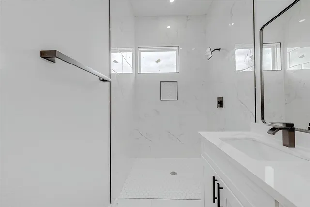 a bathroom with a sink a shower and a mirror