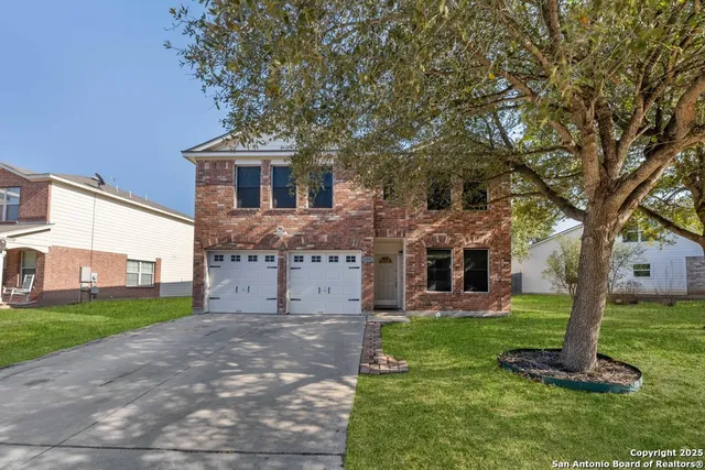 a front view of a house with a garden and trees