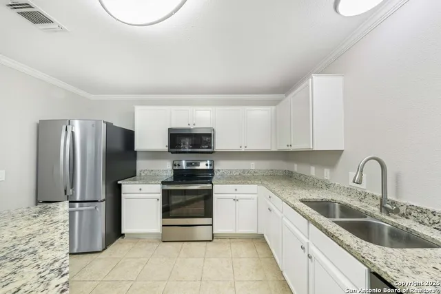 a kitchen with a sink appliances and cabinets