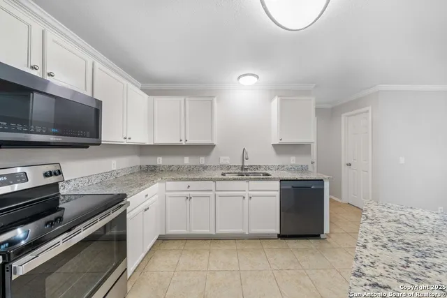 a kitchen with stainless steel appliances granite countertop a stove sink and cabinets