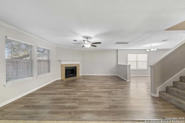 a view of empty room with wooden floor and fireplace
