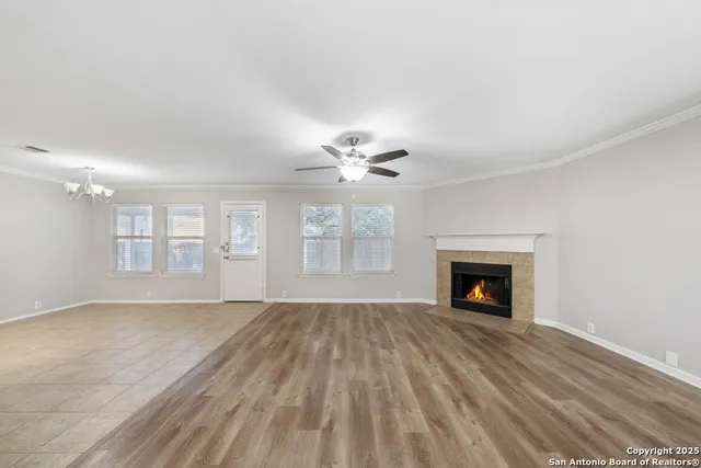 a view of an empty room with window and wooden floor