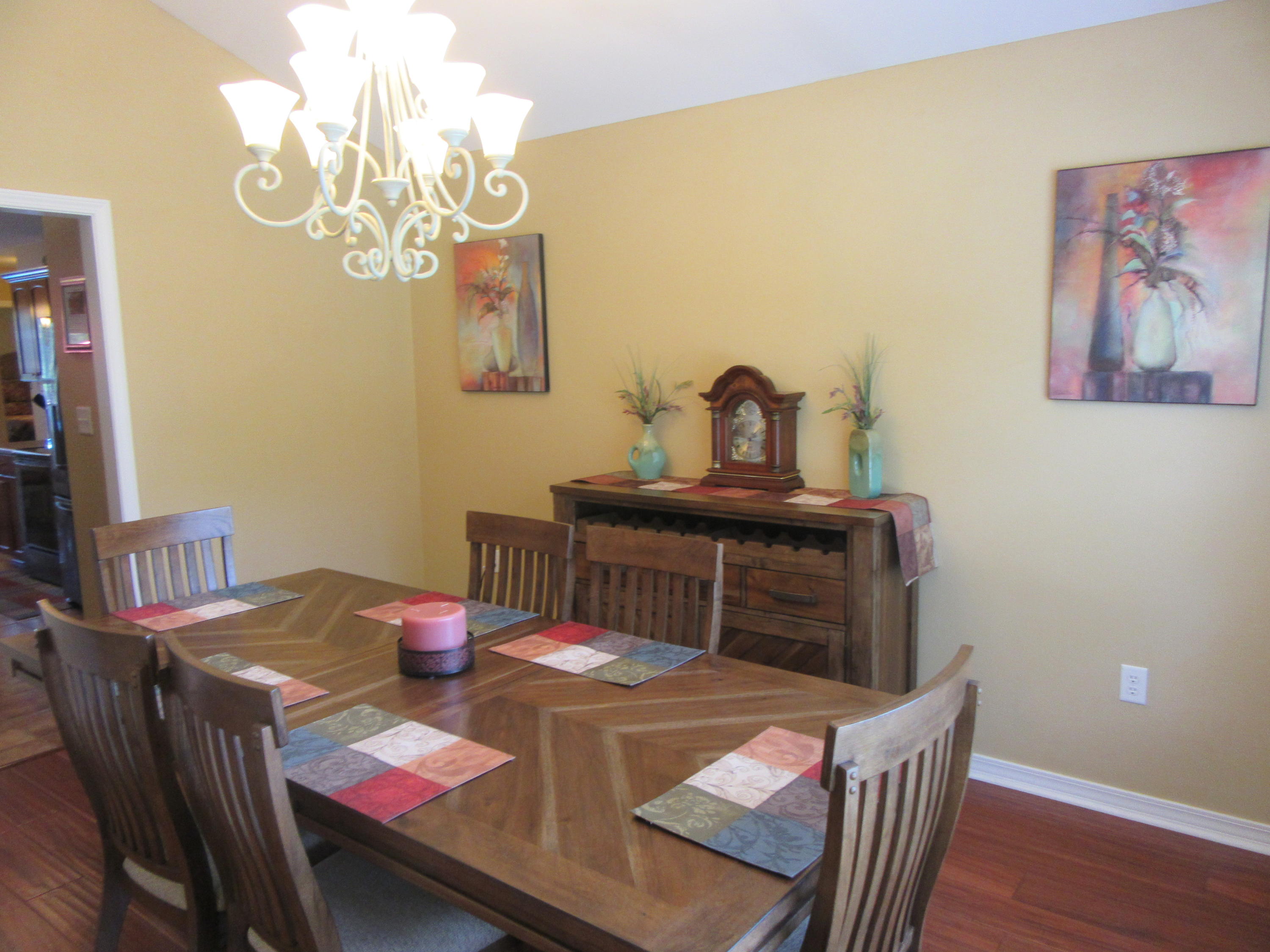 5968 Buckward Road Baker, FL 32531 - Photo 29 of 52 a view of a dining room with furniture a chandelier and wooden floor