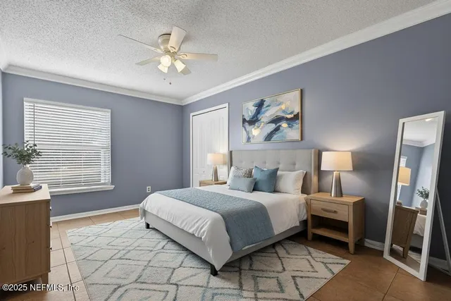a bedroom with a large bed a chandelier and a window