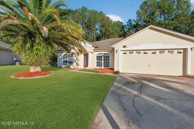 a view of a white house with a yard